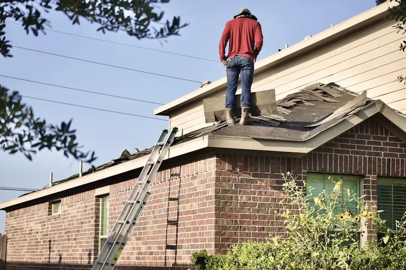 Professional roofer working on a residential roof in Oronoque